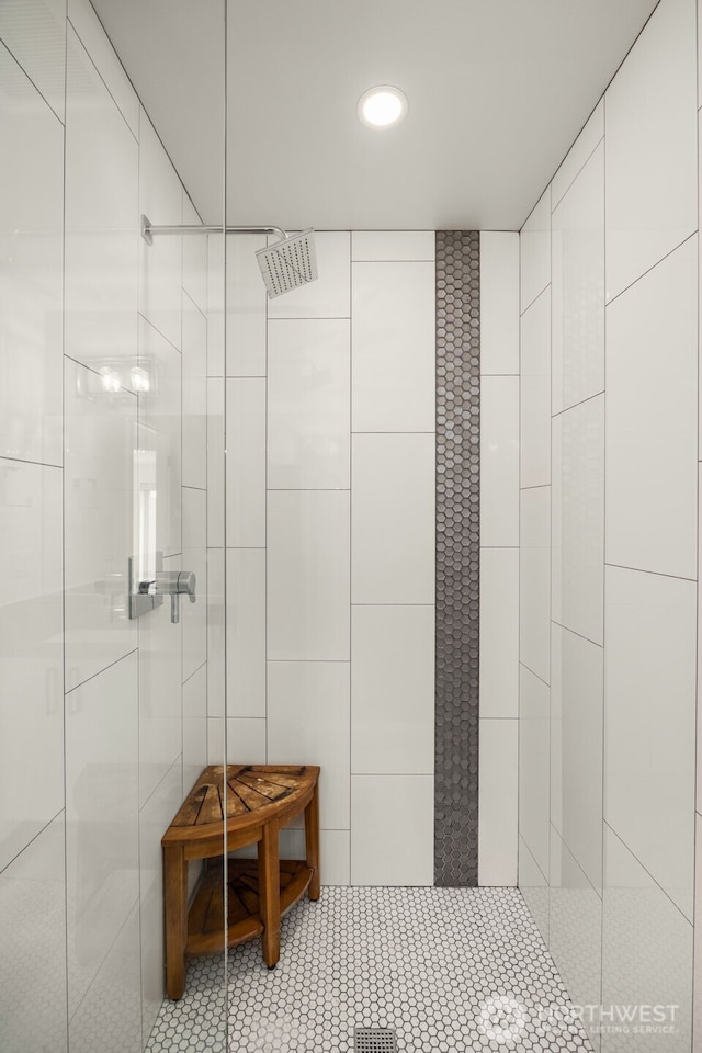 bathroom with a tile shower, tile walls, recessed lighting, and tile patterned flooring