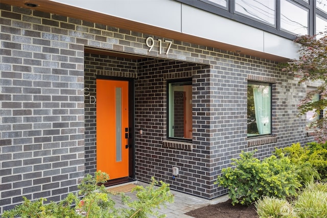 view of exterior entry featuring brick siding