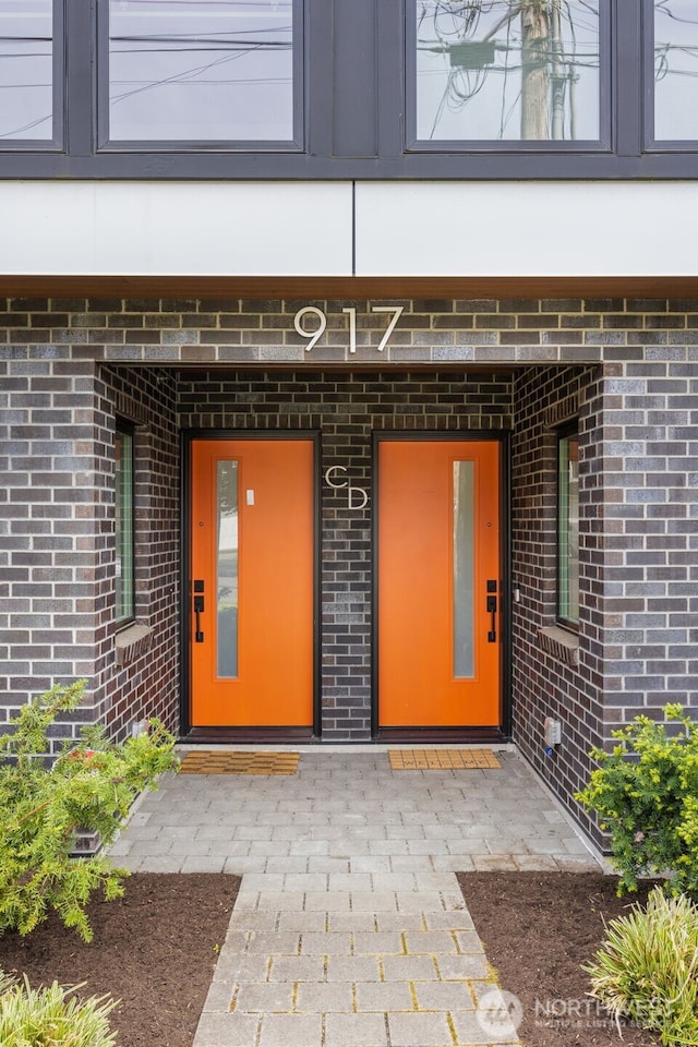 entrance to property featuring brick siding