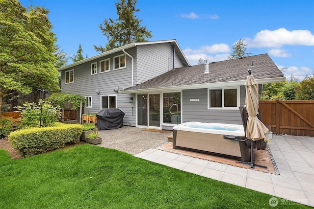 rear view of property with a hot tub, a patio area, and roof with shingles