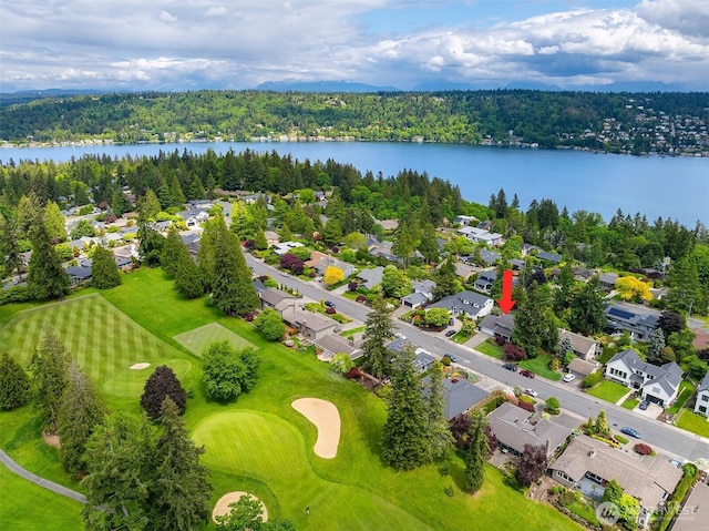 aerial perspective of suburban area with a nearby body of water and a golf course