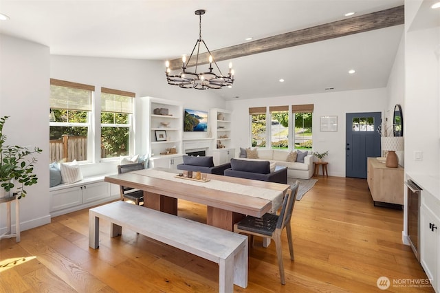 dining room featuring a chandelier, a fireplace, light wood-type flooring, healthy amount of natural light, and recessed lighting