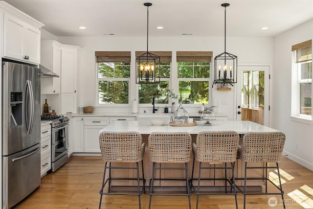 kitchen featuring stainless steel appliances, a chandelier, plenty of natural light, white cabinetry, and recessed lighting
