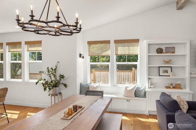 dining space featuring a chandelier, plenty of natural light, light wood-style floors, and lofted ceiling