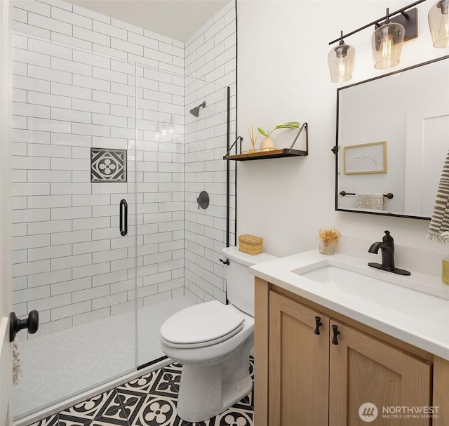 full bathroom with a stall shower, toilet, and vanity