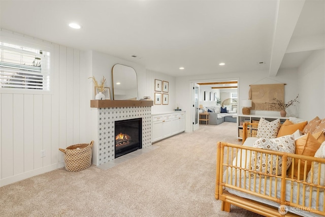 living room with light colored carpet, a tile fireplace, and recessed lighting