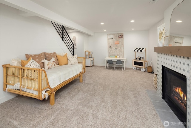 living room featuring carpet flooring, a tile fireplace, recessed lighting, stairs, and baseboards