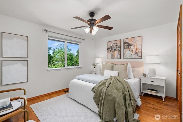 bedroom featuring baseboards, a ceiling fan, and wood finished floors