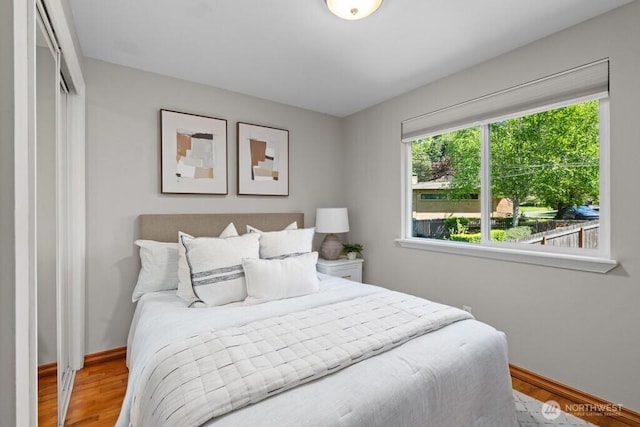 bedroom with baseboards, a closet, and wood finished floors