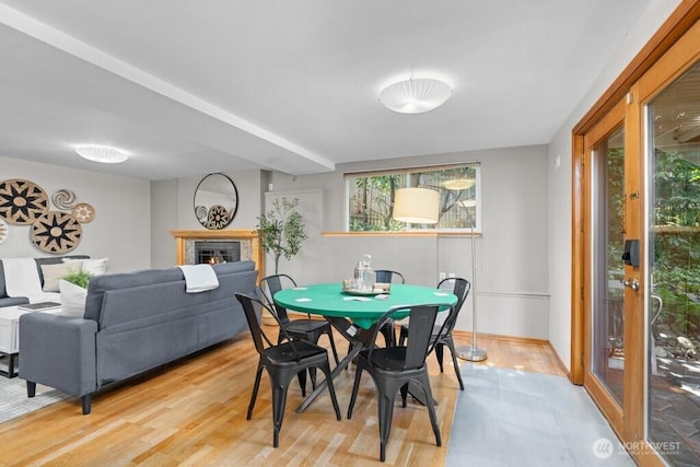 dining area with a lit fireplace and baseboards