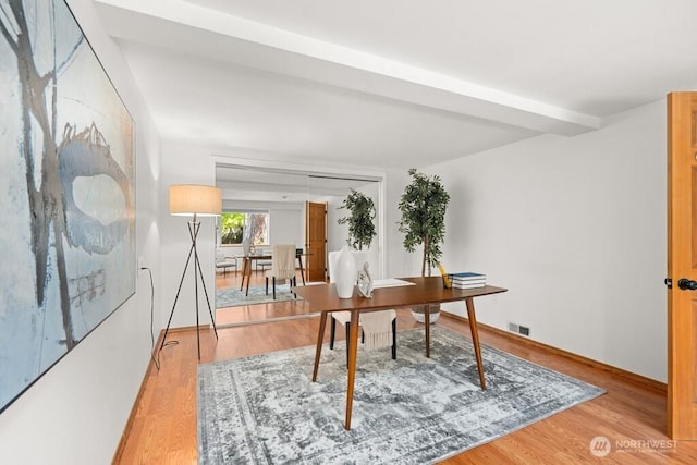 home office with light wood-style flooring and visible vents