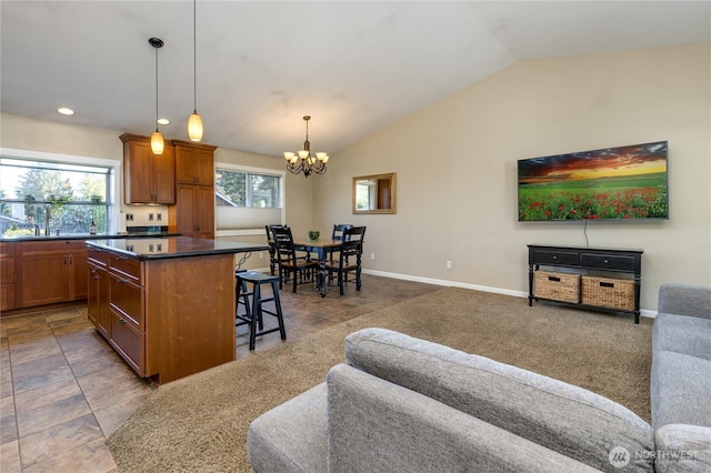 kitchen featuring a chandelier, a breakfast bar, open floor plan, a kitchen island, and dark countertops