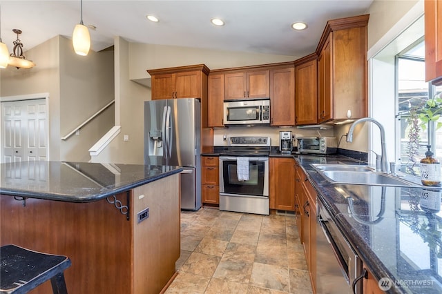 kitchen with stainless steel appliances, a sink, brown cabinetry, vaulted ceiling, and dark stone counters