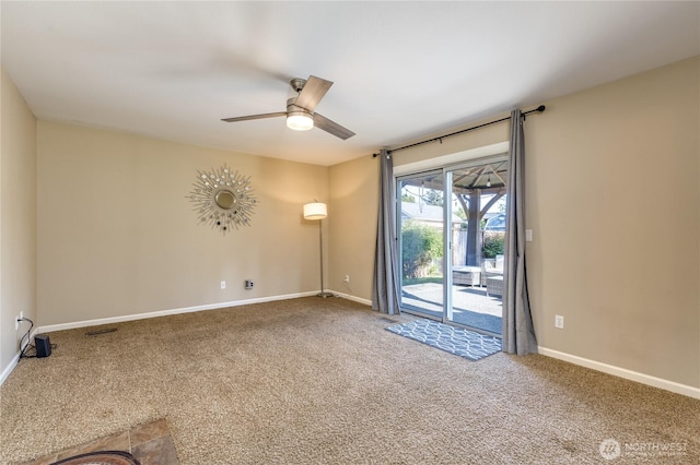carpeted empty room featuring a ceiling fan and baseboards