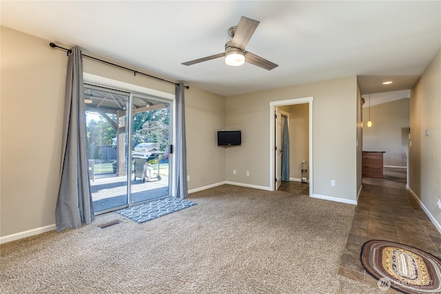 carpeted empty room with a ceiling fan and baseboards