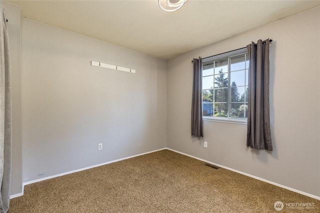 carpeted empty room featuring baseboards