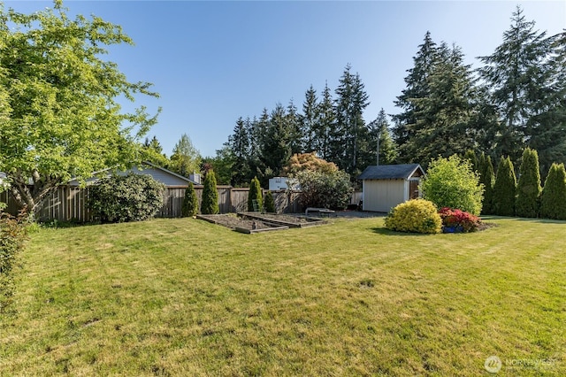 view of yard featuring a vegetable garden, a storage unit, and an outdoor structure