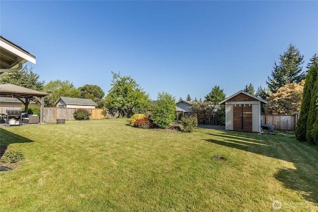 view of yard featuring a gazebo, a shed, and an outbuilding