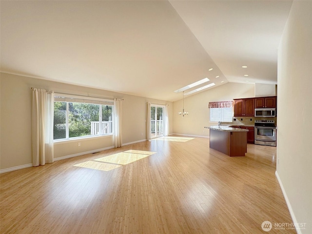 unfurnished living room with vaulted ceiling, baseboards, light wood finished floors, and a chandelier