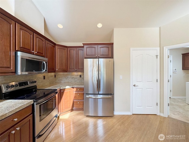 kitchen featuring appliances with stainless steel finishes, light wood-style flooring, decorative backsplash, vaulted ceiling, and recessed lighting