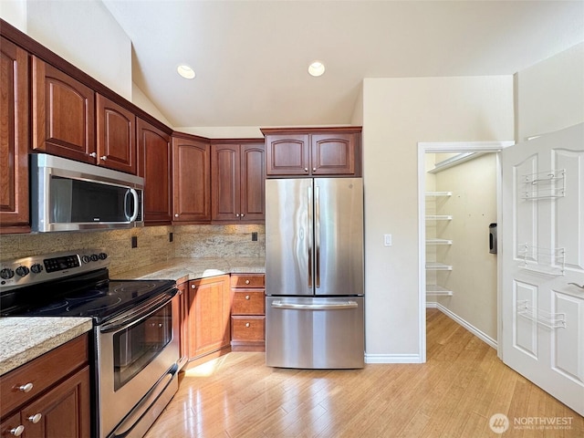 kitchen with appliances with stainless steel finishes, light wood finished floors, backsplash, lofted ceiling, and recessed lighting
