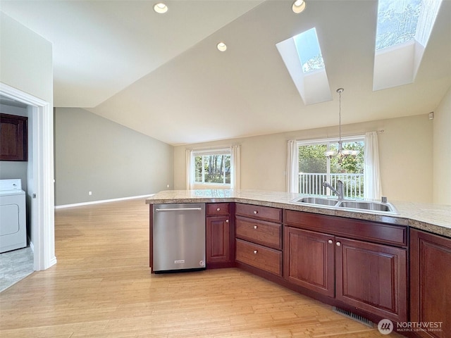 kitchen with washer / dryer, dishwasher, a skylight, light wood finished floors, and lofted ceiling