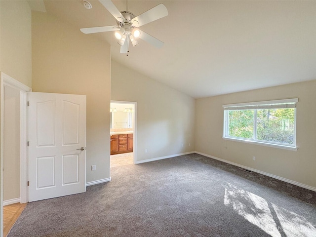 unfurnished bedroom with carpet floors, vaulted ceiling, baseboards, and ensuite bathroom