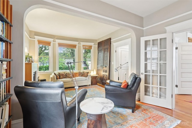 living room with wood finished floors and arched walkways