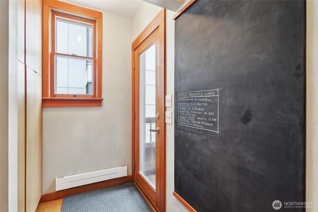 doorway with a baseboard heating unit and baseboards