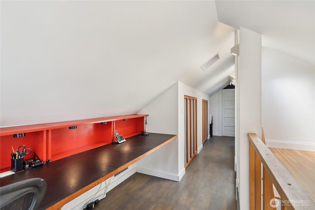 hallway featuring lofted ceiling, wood finished floors, an office area, a sink, and baseboards