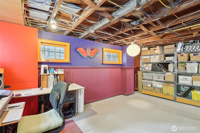 office area featuring wainscoting and concrete flooring