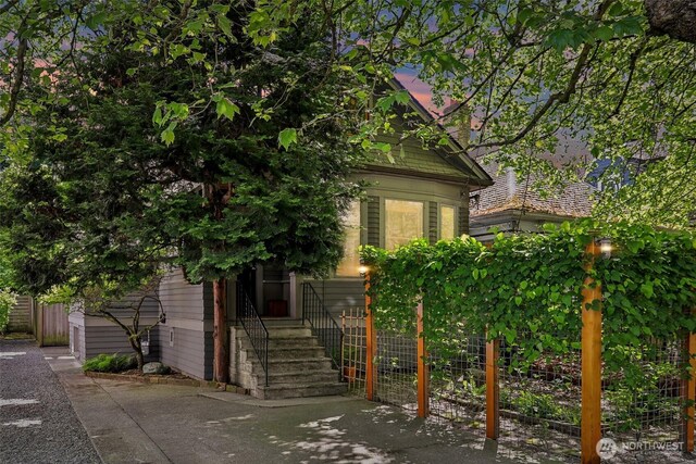 view of property hidden behind natural elements featuring fence