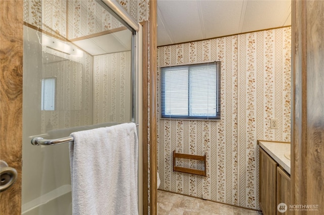 full bath featuring an enclosed shower, vanity, wallpapered walls, and crown molding