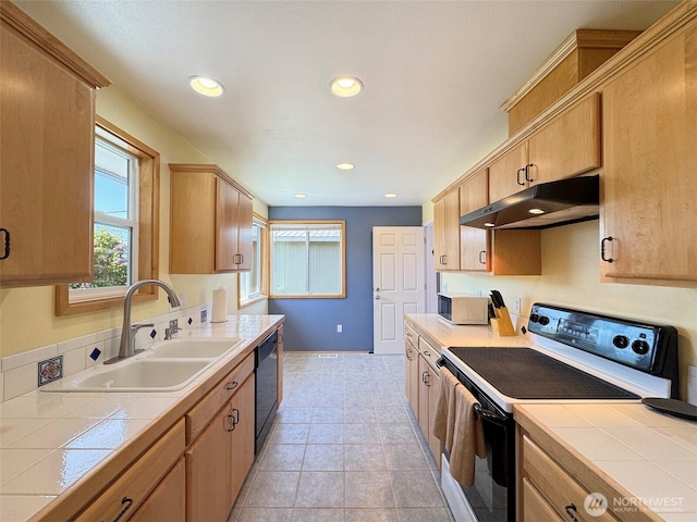 kitchen featuring under cabinet range hood, range with electric cooktop, black dishwasher, a sink, and tile countertops
