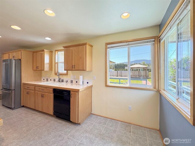 kitchen with freestanding refrigerator, a sink, black dishwasher, healthy amount of natural light, and recessed lighting