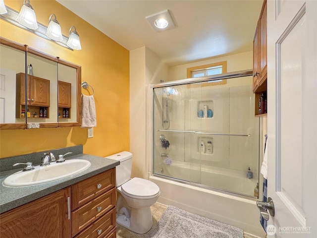 full bath featuring vanity, toilet, combined bath / shower with glass door, and tile patterned floors