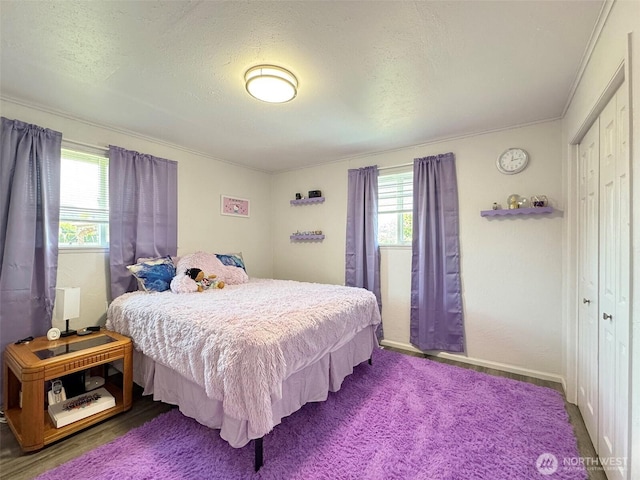 bedroom featuring multiple windows, crown molding, baseboards, and a textured ceiling