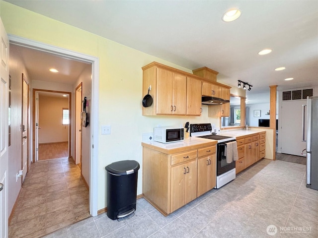 kitchen featuring electric range oven, white microwave, light brown cabinetry, under cabinet range hood, and tile countertops