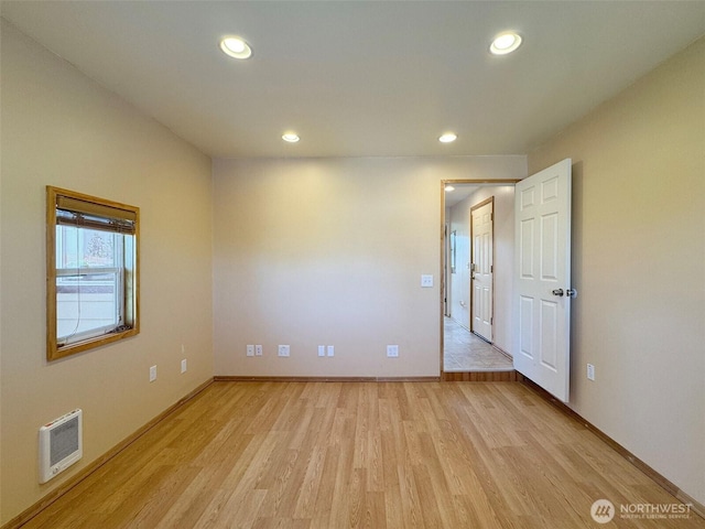 empty room with light wood-type flooring, recessed lighting, and baseboards