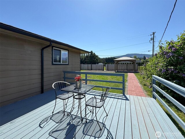 wooden terrace with a gazebo and a fenced backyard