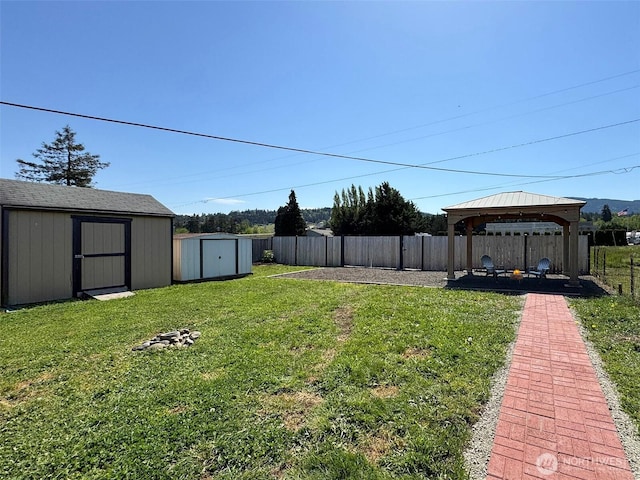 view of yard featuring a storage unit, a gazebo, and an outbuilding