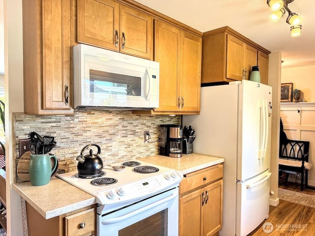 kitchen featuring white appliances, decorative backsplash, brown cabinetry, and light countertops