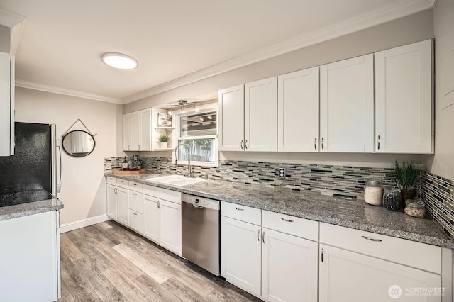 kitchen with appliances with stainless steel finishes, a sink, crown molding, white cabinetry, and light wood-type flooring