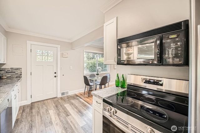 kitchen with stainless steel appliances, ornamental molding, white cabinetry, light wood finished floors, and baseboards