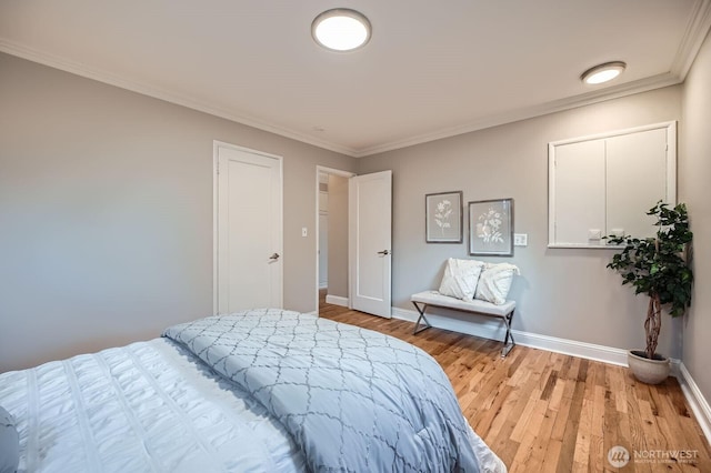 bedroom featuring crown molding, light wood-type flooring, and baseboards