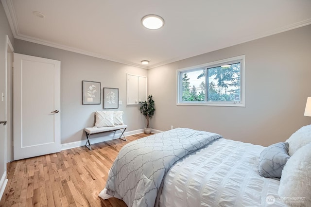 bedroom with light wood-style flooring, baseboards, and ornamental molding