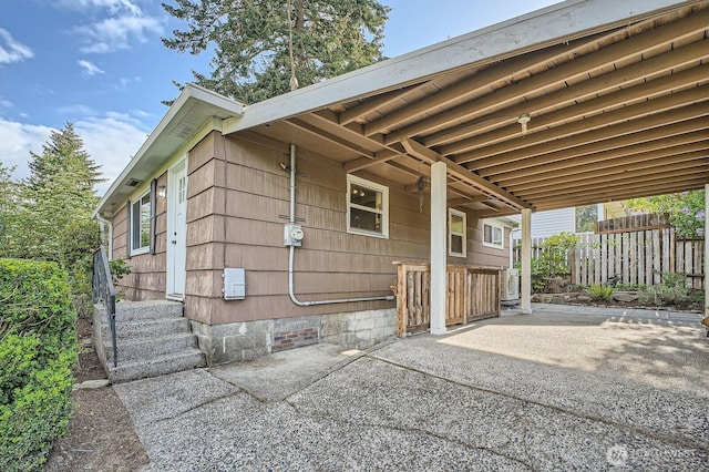 view of side of home with fence, entry steps, and a patio