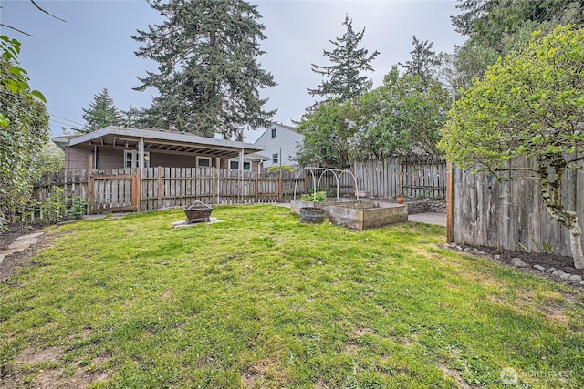 view of yard featuring an outdoor fire pit and a vegetable garden