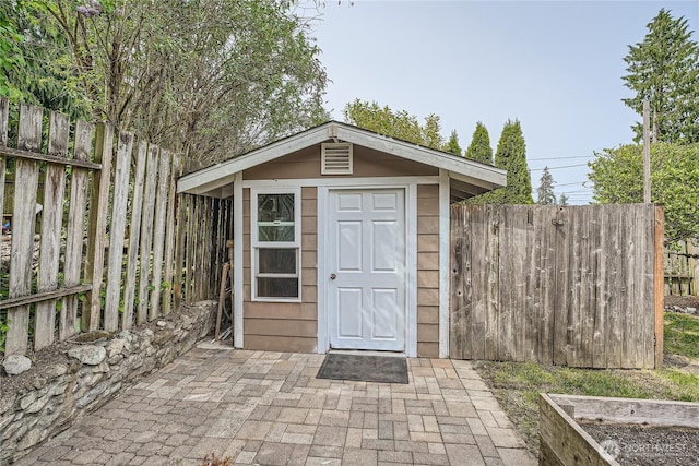 view of shed with fence and a vegetable garden