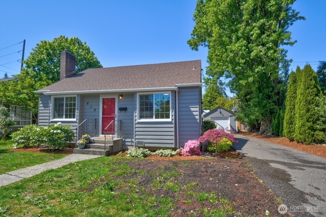 819 Decatur St SW, Olympia, WA 98502 - view of front of property with a detached garage, a shingled roof, a chimney, and an outbuilding